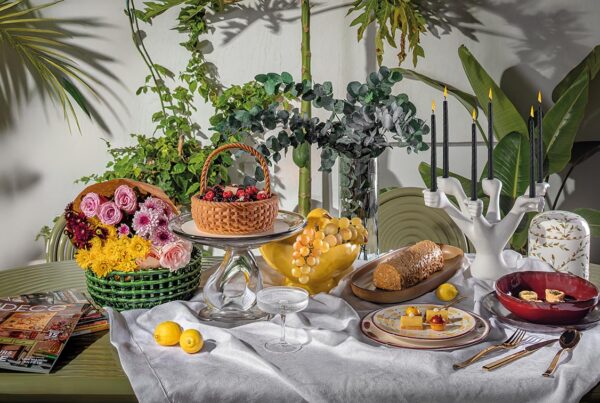 Groove Obroun table de Tom Dixon, centre de table Damo et panier en céramique de Ferm Living chez Clay Concept Store Nappe de table Le Jacquard Français chez Descamps Set de table Steel de Couzon, bougeoir Eve Hands de Jonathan Adler chez Rouge Ivoire Boite florale décorative chez Chabi Chic Assiette profonde La Mère de Serax chez Hagen Service de table Aura de Sarah Lavoine et assiette à dessert Terra Wine de L'Objet chez Nuances Maisons Bûche chez Les Ateliers du Chef Gâteau Le Panier de Chef Hajar Hour